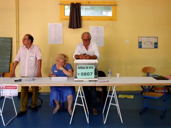 Electoral staff members wait for voters at a polling station, during the second round of French parliamentary election in Marseille, France June 18, 2017. REUTERS/Jean-Paul Pelissier
