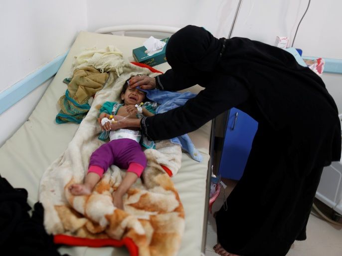 A woman helps her son as he lies on a bed at a cholera treatment center in Sanaa, Yemen May 15, 2017. Picture taken May 15, 2017. REUTERS/Khaled Abdullah