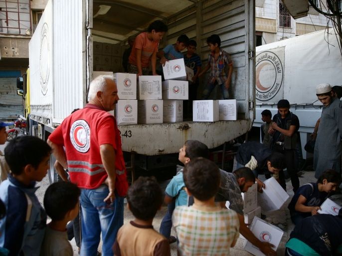 People unload parcels of humanitarian aid in the rebel held besieged Harasta area, in the eastern Damascus suburb of Ghouta, Syria, June 19, 2017. REUTERS/Bassam Khabieh