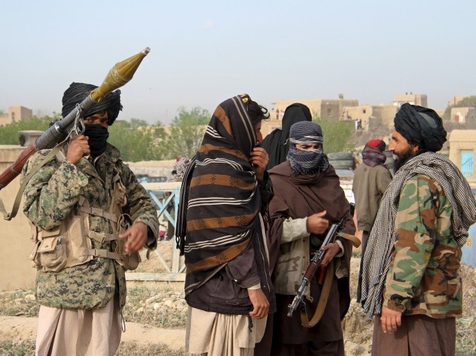 Members of the Taliban gather at the site of the execution of three men accused of murdering a couple during a robbery in Ghazni Province April 18, 2015. The Taliban announced the execution of the three men accused of murdering a couple during a robbery, saying they had been tried by an Islamic court. The killing was carried out in front of a crowd by Taliban fighters who fired at the men with AK-47s, according to a Reuters witness. Footage seen by Reuters show the men