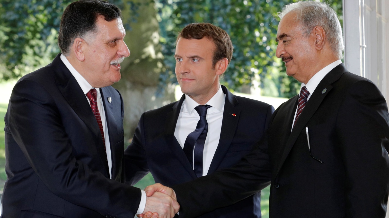  الرئيس الفرنسي ماكرون يقف بين الجنرال خليفة حفتر ورئيس حكومة الوفاق فايز السرّاج (رويترز)