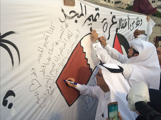 السفير القطري خلال توقيع على جدارية تضامن من أطفال غزة مع قطر