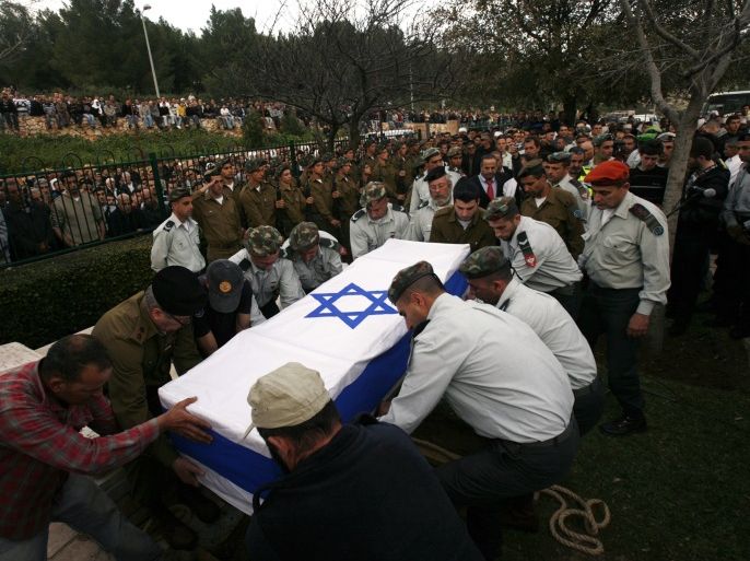 Israeli soldiers lower the flag-draped coffin of their comrade Ihab Chattib into a grave during his funeral in the northern Druze-Arab village of Maghar February 11, 2010. A Palestinian police officer stabbed and killed Chattib in the occupied West Bank on Wednesday, the military said, in an attack that could place more strain on U.S. efforts to revive Middle East peace talks. REUTERS/Gil Cohen Magen (ISRAEL - Tags: POLITICS CIVIL UNREST)