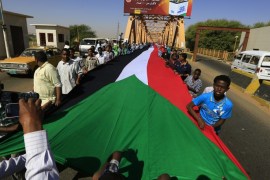 Students carry Sudan's national flag as they pass the River Nile during celebrations to mark Sudan's 59th Independence Day, in Khartoum January 1, 2015. Sudan became independent on January 1, 1956. REUTERS/Mohamed Nureldin Abdallah (SUDAN - Tags: POLITICS ANNIVERSARY SOCIETY)