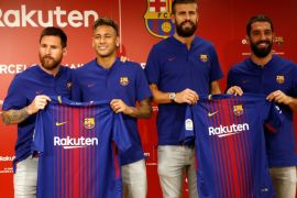 FC Barcelona players (L-R) Lionel Messi , Neymar, Gerard Pique and Arda Turan holding their uniforms pose for a photo during a news conference to announce the sponsorship deal between the team and Japanese e-commerce operator Rakuten Inc. in Tokyo, Japan July 13, 2017. REUTERS/Kim Kyung-Hoon