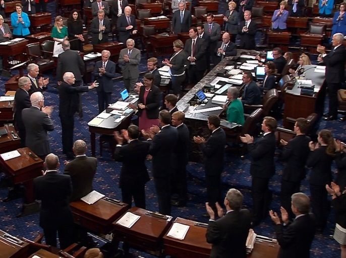 A still image from video shows U.S. Senator John McCain (R-AZ), who had been recuperating in Arizona after being diagnosed with brain cancer, acknowledging applause as he arrives on the floor of the U.S. Senate after returning to Washington for a vote on healthcare reform in Washington, U.S., July 25, 2017. SENATE TV/Handout via REUTERS THIS IMAGE HAS BEEN SUPPLIED BY A THIRD PARTY.