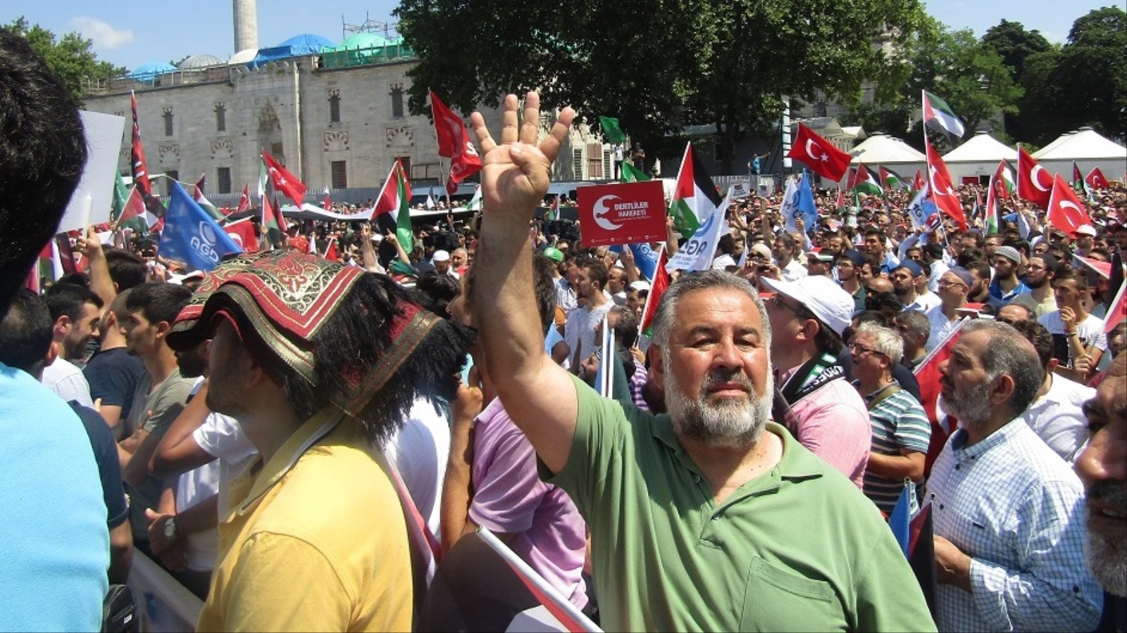 تركي يرفع شارة رابعة في وقفة الغضب للأقصى بمدينة إسطنبول (الجزيرة)
