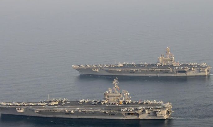 The U.S. Navy aircraft carrier USS Carl Vinson (CVN 70), bottom, is seen relieving the USS George H.W. Bush in the Arabian Gulf October 18, 2014. George H.W. Bush will soon depart the U.S. 5th Fleet area of responsibility for its homeport at Norfolk, Virginia, and Carl Vinson will take over support of maritime security operations, strike operations in Iraq and Syria REUTERS/US Navy/Mass Communication Specialist 2nd Class Korrin Kim/Handout via Reuters (MID SEA - Tags: