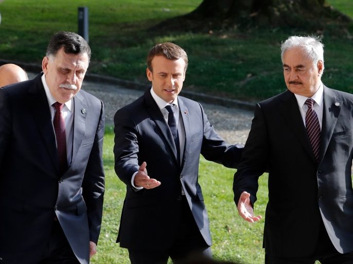 French President Emmanuel Macron points as he arrives with Libyan Prime Minister Fayez al-Sarraj (L), and General Khalifa Haftar (R), commander in the Libyan National Army (LNA), after talks over a political deal to help end Libya’s crisis in La Celle-Saint-Cloud near Paris, France, July 25, 2017. REUTERS/Philippe Wojazer
