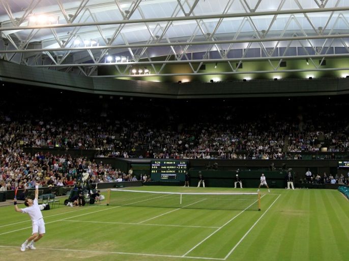 FILE PHOTO: Andy Murray of Britain (FOREGROUND) serves to Ivan Ljubicic of Croatia under the closed roof on Centre Court at the Wimbledon tennis championships in London, Britain, June 24, 2011. REUTERS/Stefan Wermuth/File Photo