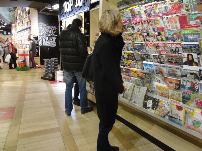 سيدة سلوفاكية أمام أعداد من المجلات والجرائد المحلية في مكتبة في براتيسلافا