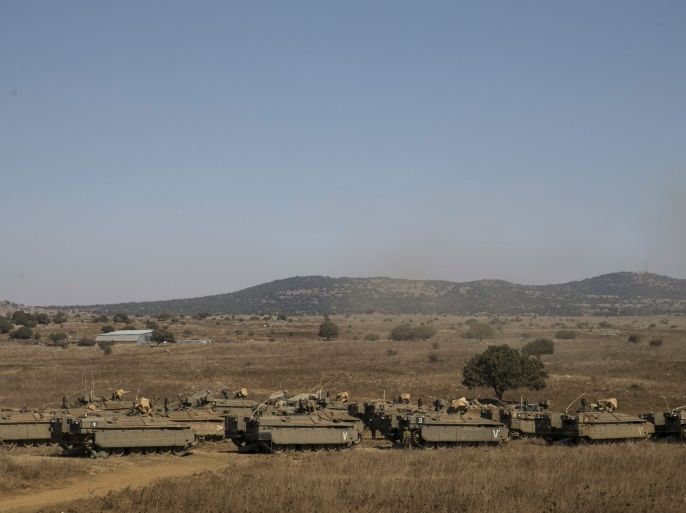 Israeli soldiers walk next to armoured personnel carriers (APC) in the Israeli-occupied Golan Heights, near the ceasefire line between Israel and Syria August 21, 2015. Israel said it killed at least five Palestinian militants in an air strike on the Syrian Golan Heights on Friday, after cross-border rocket fire from there prompted the heaviest Israeli bombardment since the start of Syria's four-year-old civil war. REUTERS/Baz Ratner