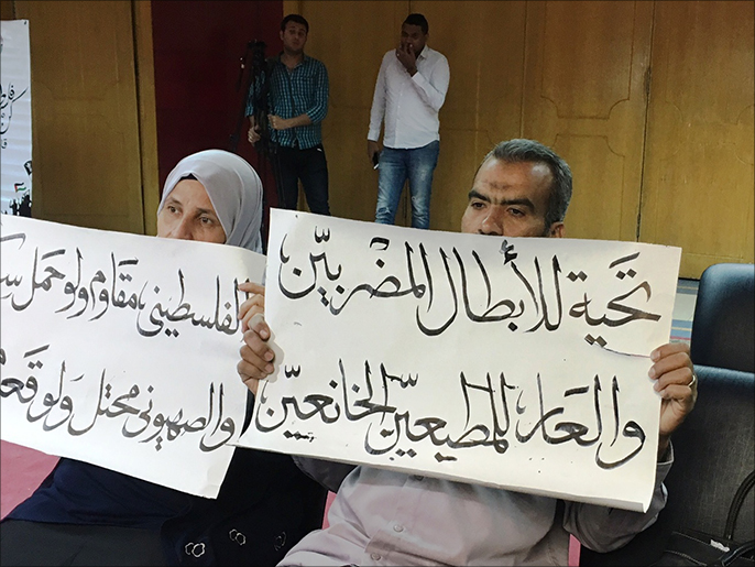 ‪مصريان يحملان لافتة تضامن مع الأسرى الفلسطينين المضربين عن الطعام‬ (الجزيرة نت)