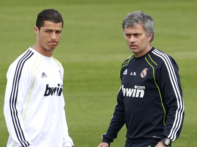 Real Madrid coach Jose Mourinho walks next to Cristiano Ronaldo (L) during a training session at the Valdebebas training grounds outside Madrid April 19, 2011. Mourinho must resolve a tactical dilemma when he attempts to land his first piece of silverware as Real Madrid coach in Wednesday's King's Cup final against Barcelona at Valencia's Mestalla stadium. REUTERS/Andrea Comas (SPAIN - Tags: SPORT SOCCER)