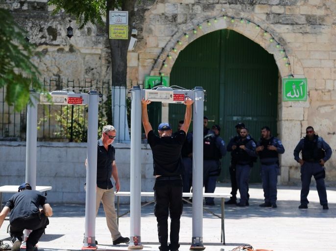 Men install metal detectors at an entrance to the compound known to Muslims as Noble Sanctuary and to Jews as Temple Mount, in Jerusalem's Old City July 16, 2017. REUTERS/Ammar Awad