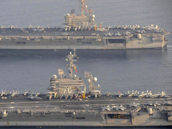 The U.S. Navy aircraft carrier USS Carl Vinson (CVN 70), bottom, is seen relieving the USS George H.W. Bush in the Arabian Gulf October 18, 2014. George H.W. Bush will soon depart the U.S. 5th Fleet area of responsibility for its homeport at Norfolk, Virginia, and Carl Vinson will take over support of maritime security operations, strike operations in Iraq and Syria REUTERS/US Navy/Mass Communication Specialist 2nd Class Korrin Kim/Handout via Reuters (MID SEA - Tags: