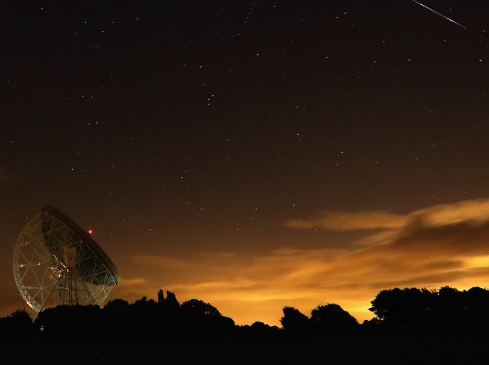 HOLMES CHAPEL, UNITED KINGDOM - AUGUST 13: A Perseid meteor (R) streaks across the sky past the light trail of an aircraft over the Lovell Radio Telescope at Jodrell Bank on August 13, 2013 in Holmes Chapel, United Kingdom.The annual display, known as the Perseid shower because the meteors appear to radiate from the constellation Perseus in the northeastern sky, is a result of Earth's orbit passing through debris from the comet Swift-Tuttle. (Photo by Christopher Fur