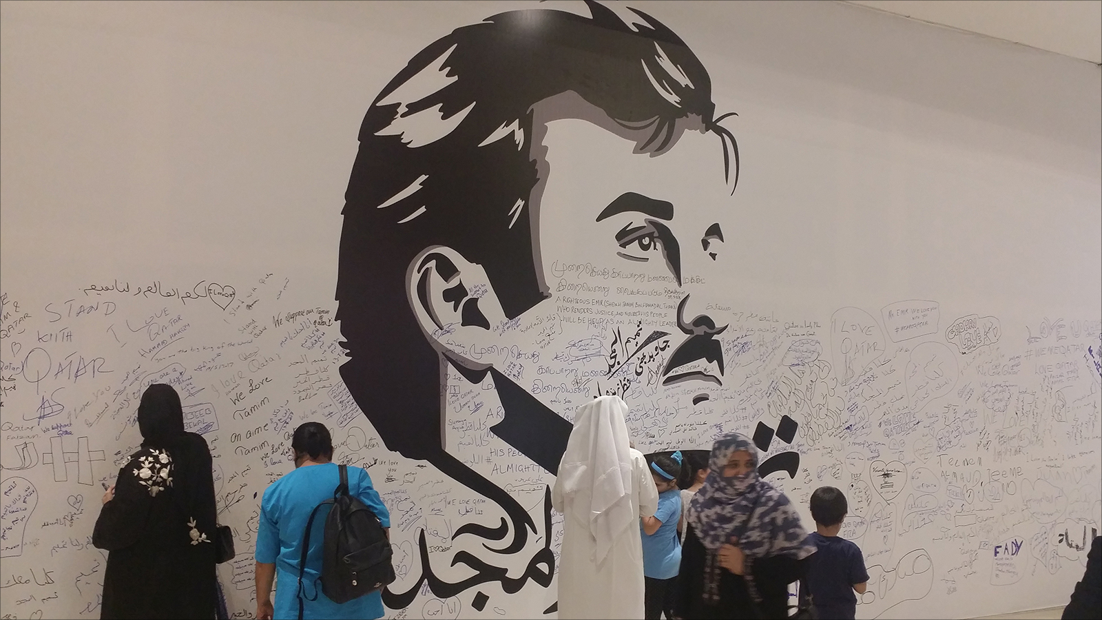 ‪‬ توقيعات المواطنين والمقيمين على جدارية تميم المجد(الجزيرة نت)