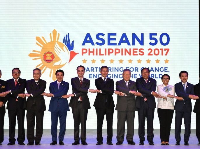 Malaysia's Foreign Minister Anifah Aman, Myanmar Minister of State of Foreign Affairs U Kyaw Tin, Thailand Foreign Minister Don Pramudwinai, Vietnam's Foreign Minister Pham Binh Minh, Philippine Foreign Secretary Alan Peter Cayetano, Singapore's Foreign Minister Vivian Balakrishnan, Brunei's Foreign Minister Lim Jock Seng, Cambodia's Foreign Minister Prak Sokhonn, Indonesia's Foreign Minister Retno Marsudi, Laos' Foreign Minister Saleumxay Kommasith and ASEAN Secretary-General Le Luong Minh join hands for a family photo during opening ceremony of the 50th Association of Southeast Asian Nations (ASEAN) Regional Forum (ARF) meeting in Manila on August 5, 2017. REUTERS/Mohd Rasfan/Pool