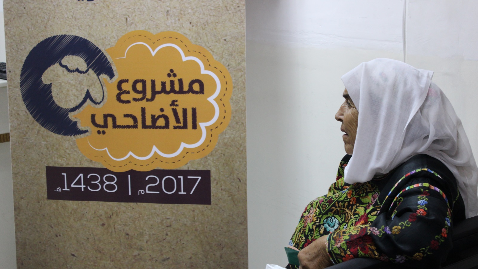 المسنة حنان دغش تنتظر دورها في مقر لجنة الزكاة للحصول على قسيمة مشروع الأضاحي (الجزيرة)