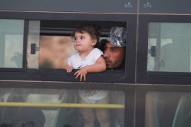 A Syrian man with a child is seen in a bus in Jroud Arsal, Lebanon August 2, 2017. REUTERS/Mohamed Azakir