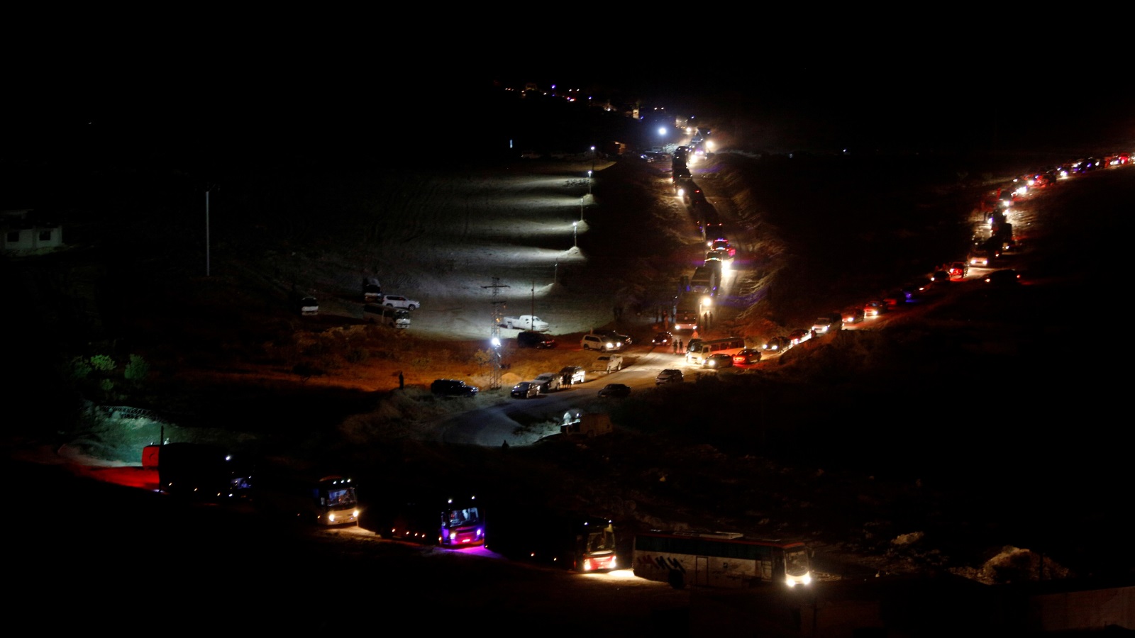 ‪القافلة أثناء سيرها الليلة الماضية في منطقة فليطة السورية‬ (رويترز)