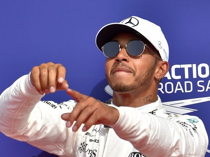Mercedes' British driver Lewis Hamilton celebrates winning the pole position after the qualifying session at the Spa-Francorchamps circuit in Spa on August 26, 2017 ahead of the Belgian Formula One Grand Prix. / AFP PHOTO / LOIC VENANCE (Photo credit should read LOIC VENANCE/AFP/Getty Images)