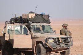A U.S. fighter stands near a military vehicle, north of Raqqa city, Syria November 6, 2016. REUTERS/Rodi Said