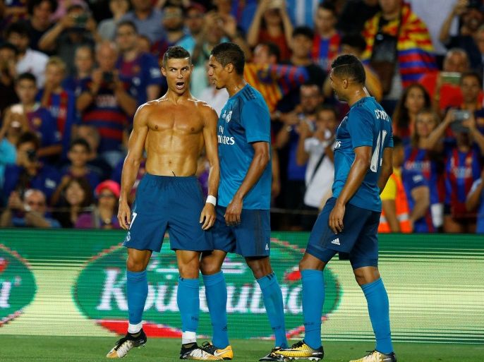 Soccer Football - Barcelona v Real Madrid Spanish Super Cup First Leg - Barcelona, Spain - August 13, 2017 Real Madrid’s Cristiano Ronaldo celebrates scoring their second goal with Raphael Varane and Casemiro and is later booked for removing his shirt REUTERS/Juan Medina
