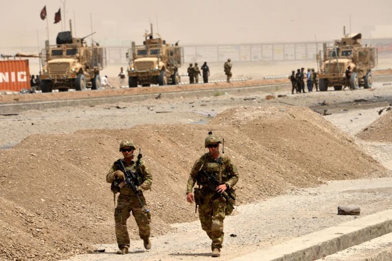 US soldiers walk at the site of a Taliban suicide attack in Kandahar on August 2, 2017.A Taliban suicide bomber on August 2 rammed a vehicle filled with explosives into a convoy of foreign forces in Afghanistan's restive southern province of Kandahar, causing casualties, officials said. 'At around noon a car bomb targeted a convoy of foreign forces in the Daman area of Kandahar,' provincial police spokesman Zia Durrani told AFP. / AFP PHOTO / JAVED TANVEER        (Photo credit should read JAVED TANVEER/AFP/Getty Images)