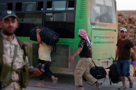 Syrian men carry their bags near a bus in Jroud Arsal, Lebanon August 2, 2017. REUTERS/ Mohamed Azakir