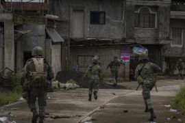 MARAWI, PHILIPPINES - JULY 22: Philippine Marines soldiers in a cleared street but are still in range of enemy sniper fire as they walk towards the main battle area on July 22, 2017 in Marawi, southern Philippines. The Philippine Congress voted on Saturday to extend martial law in the southern part of the country since it was imposed to crush a rebellion by Islamic State-inspired militants. The decision was made two days before President Rodrigo Duterte delivers his annual state of the nation address as analysts have reportedly said Mr. Duterte appears to be using the crisis in Marawi as an excuse to impose authoritarian rule in the Philippines. (Photo by Jes Aznar/Getty Images)