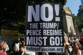 A protester holds a sign reading "No! The Trump/Pence regime must go!" in New York City, the day after the attack on counter-protesters at the "Unite the Right" rally organized by white nationalists in Charlottesville, Virginia, U.S., August 13, 2017. REUTERS/Joe Penney