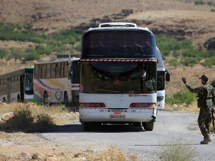 A Hezbollah fighter is seen escorting buses in Jroud Arsal, near Syria-Lebanon border, August 13, 2017. REUTERS/Ali Hashisho