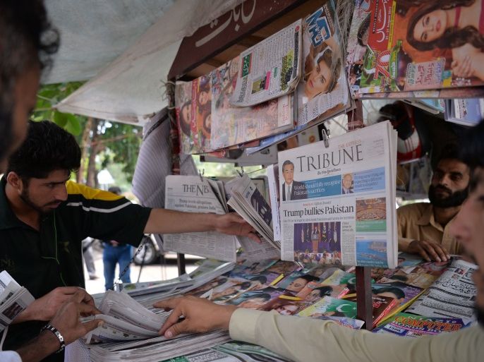 Pakistani residents buy newspapers with front page headlines about US President Donald Trump at a stall in Islamabad on August 23, 2017.Angry and offended Pakistanis fired back on August 23 against Donald Trump's accusations that their country harbours militants, highlighting the heavy toll they have paid fighting extremism and slamming his embrace of arch-rival India. / AFP PHOTO / AAMIR QURESHI / TO GO WITH 'PAKISTAN-US-AFGHANISTAN-DIPLOMACY', FOCUS by Sajjad TARAZ