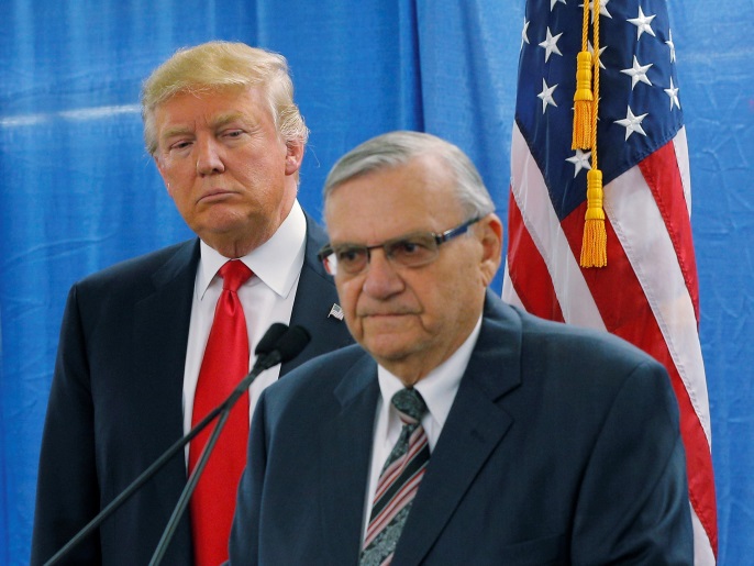 FILE PHOTO: U.S. Republican presidential candidate Donald Trump listens as Maricopa County Sheriff Joe Arpaio (R) speaks to reporters before a campaign rally in Marshalltown, Iowa January 26, 2016. REUTERS/Brian Snyder/File Photo