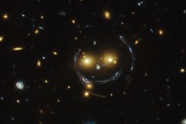 The galaxy cluster SDSS J1038+4849 is pictured in this undated handout image taken with the NASA/ESA Hubble Space Telescope. As a result of the phenomenon of gravitational lensing, it seems to be smiling. In the case of this