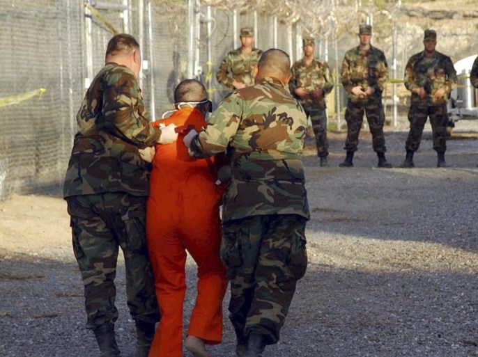 U.S. Army Military Police escort a detainee to his cell during in-processing to the temporary detention facility at Camp X-Ray in Naval Base Guantanamo Bay in this file photograph taken January 11, 2002 and released January 18, 2002. Al Qaeda leader Osama bin Laden was killed in a firefight with U.S. forces in Pakistan on May 1, 2011, ending a nearly 10-year worldwide hunt for the mastermind of the Sept. 11 attacks.