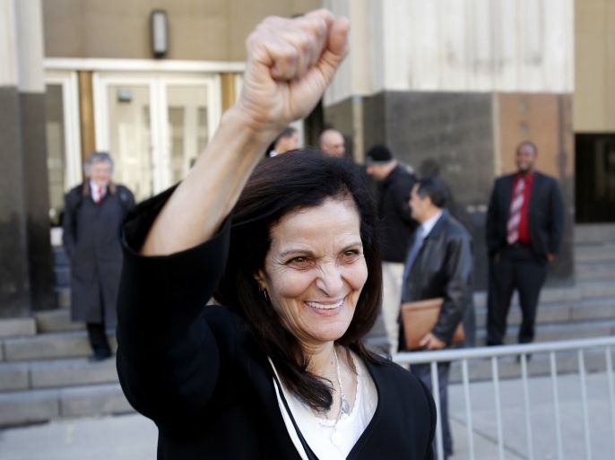 Palestinian activist Rasmieh Yousef Odeh raises her fist as she leaves the federal courthouse with supporters after her sentencing in Detroit, Michigan March 12, 2015. Odeh was sentenced to 18 months in prison on Thursday for immigration fraud for failing to tell U.S. authorities that she had been imprisoned in Israel for a 1969 supermarket bombing that killed two people. REUTERS/Rebecca Cook (UNITED STATES - Tags: CRIME LAW SOCIETY IMMIGRATION)