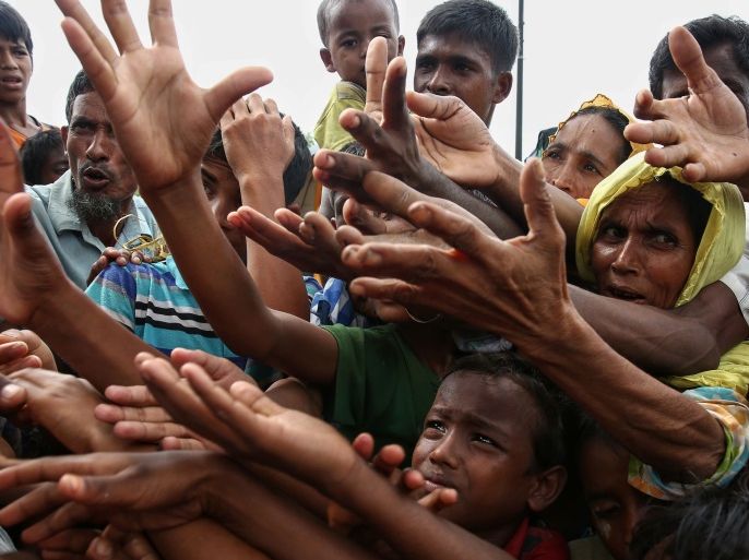 This August 30, 2017 photo shows Rohingya refugees reaching for food aid at Kutupalong refugee camp in Ukhiya near the Bangladesh-Myanmar border.The International Organization for Migration said August 30 that at least 18,500 Rohingya had crossed into Bangladesh since fighting erupted in Myanmar's neighbouring Rakhine state six days earlier. / AFP PHOTO / STR (Photo credit should read STR/AFP/Getty Images)