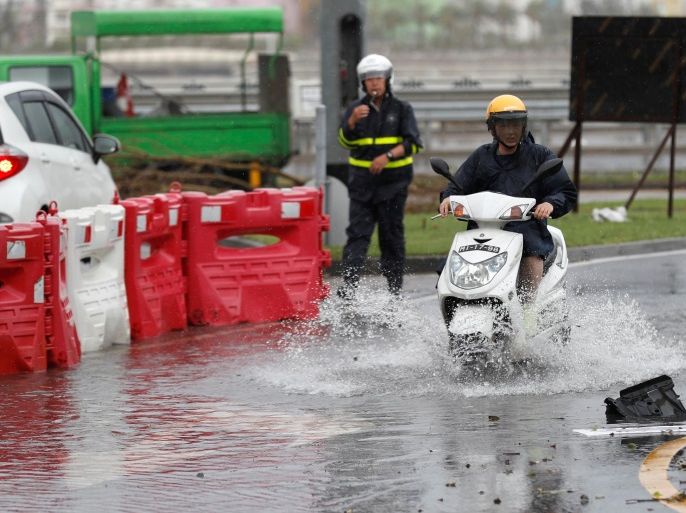 A man rides a motorbike on a flooded street during tropical storm Pakhar hits Macau, China August 27, 2017. REUTERS/Tyrone Siu