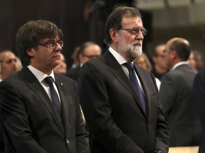 President of the Generalitat of Catalonia Carles Puigdemont and Spanish Prime Minister Mariano Rajoy are seen at a High mass celebrated in memory of the victims of the van attack at Las Ramblas earlier this week, at the Basilica of the Sagrada Familia in Barcelona, Spain August 20, 2017. REUTERS/Sergio Barrenechea/Pool