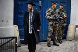 PARIS, FRANCE - JANUARY 13: Armed soldiers patrol outside a School in the Jewish quarter of the Marais district on January 13, 2015 in Paris, France. Thousands of troops and police have been deployed to bolster security at 'sensitive' sites including Jewish schools. Millions of people converged in central Paris for a Unity March joining in solidarity with the 17 victims of last week's terrorist attacks in the country. French President Francois Hollande led the march and was joined by world leaders in a sign of unity. The terrorist atrocities started on Wednesday with the attack on the French satirical magazine Charlie Hebdo, killing 12, and ended on Friday with sieges at a printing company in Dammartin en Goele and a Kosher supermarket in Paris with four hostages and three suspects being killed. A fourth suspect, Hayat Boumeddiene, 26, escaped and is wanted in connection with the murder of a policewoman. (Photo by Jeff J Mitchell/Getty Images)