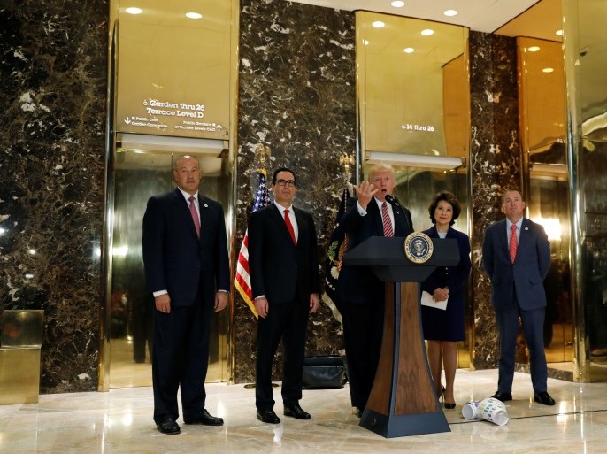 U.S. President Donald Trump is flanked by (L-R) Director of the National Economic Council Gary Cohn, Treasury Secretary Steven Mnuchin, Secretary of Transportation Elaine Chao and Director of the Office of Management and Budget Mick Mulvaney as he speaks about the violence, injuries and deaths at the