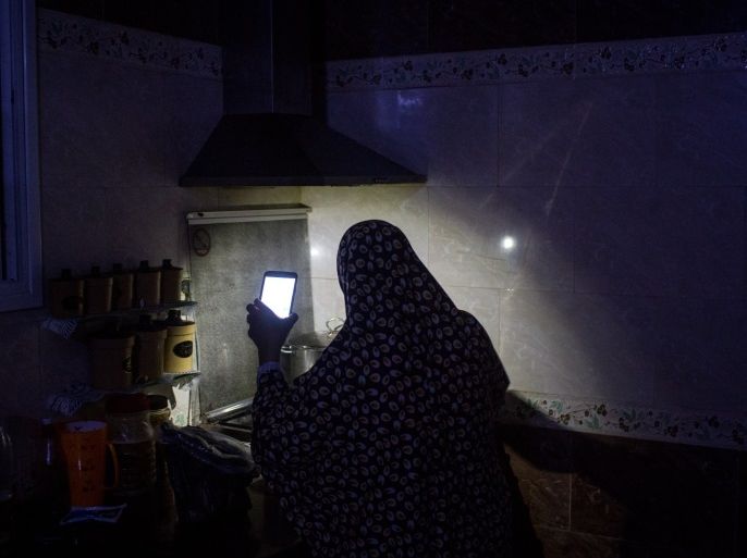 GAZA CITY, GAZA - JULY 23: Maha Zant makes tea by cell phone light at her home in the Al-Zahra district on July 23, 2017 in Gaza City, Gaza. For the past ten years Gaza residents have lived with constant power shortages, in recent years these cuts have worsened, with supply of regular power limited to four hours a day. On June 11, 2017 Israel announced a new round of cuts at the request of the Palestinian authorities and the decision was seen as an attempt by President Mahmoud Abbas to pressure Gaza's Hamas leadership. Prior to the new cuts Gaza received 150 megawatts per day, far below it's requirements of 450 megawatts. In April, Gaza's sole power station which supplied 60 megawatts shut down, after running out of fuel, the three lines from Egypt, which provided 27 megawatts are rarely operational, leaving Gaza reliant on the 125 megawatts supplied by Israel's power plant. The new cuts now restrict electricity to three hours a day severely effecting hospital patients with chronic conditions and babies on life support. During blackout hours residents use private generators, solar panels and battery operated light sources to live. June 2017 also marked ten years since Israel began a land, sea and air blockade over Gaza. Under the blockade, movement of people and goods is restricted and exports and imports of raw materials have been banned. The restrictions have virtually cut off access for Gaza's two million residents to the outside world and unemployment rates have skyrocketed forcing many people into poverty and leaving approximately 80% of the population dependent on humanitarian aid. (Photo by Chris McGrath/Getty Images)