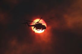 A firefighting helicopter flies in front of the setting sun as a wildfire burns near the village of Kapandriti, north of Athens, Greece, August 15, 2017. REUTERS/Alkis Konstantinidis