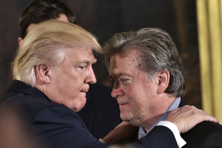 US President Donald Trump (L) congratulates Senior Counselor to the President Stephen Bannon during the swearing-in of senior staff in the East Room of the White House on January 22, 2017 in Washington, DC. / AFP / MANDEL NGAN        (Photo credit should read MANDEL NGAN/AFP/Getty Images)