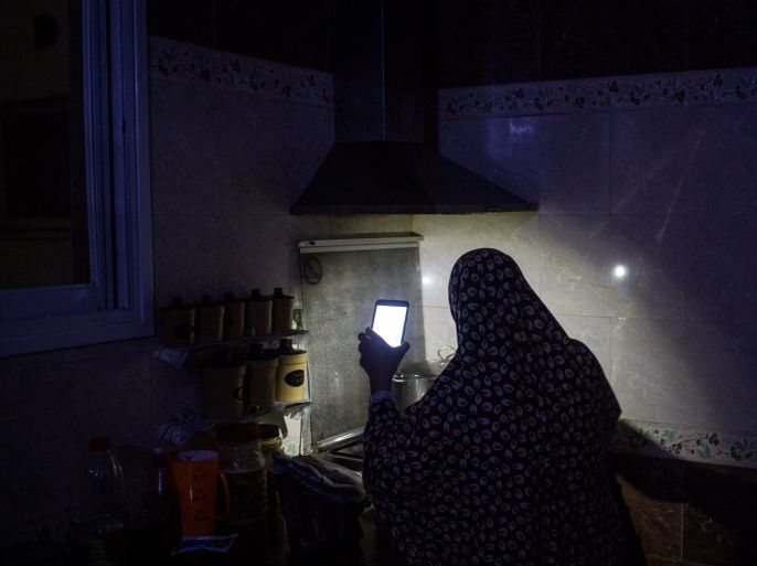GAZA CITY, GAZA - JULY 23: Maha Zant makes tea by cell phone light at her home in the Al-Zahra district on July 23, 2017 in Gaza City, Gaza. For the past ten years Gaza residents have lived with constant power shortages, in recent years these cuts have worsened, with supply of regular power limited to four hours a day. On June 11, 2017 Israel announced a new round of cuts at the request of the Palestinian authorities and the decision was seen as an attempt by Presiden