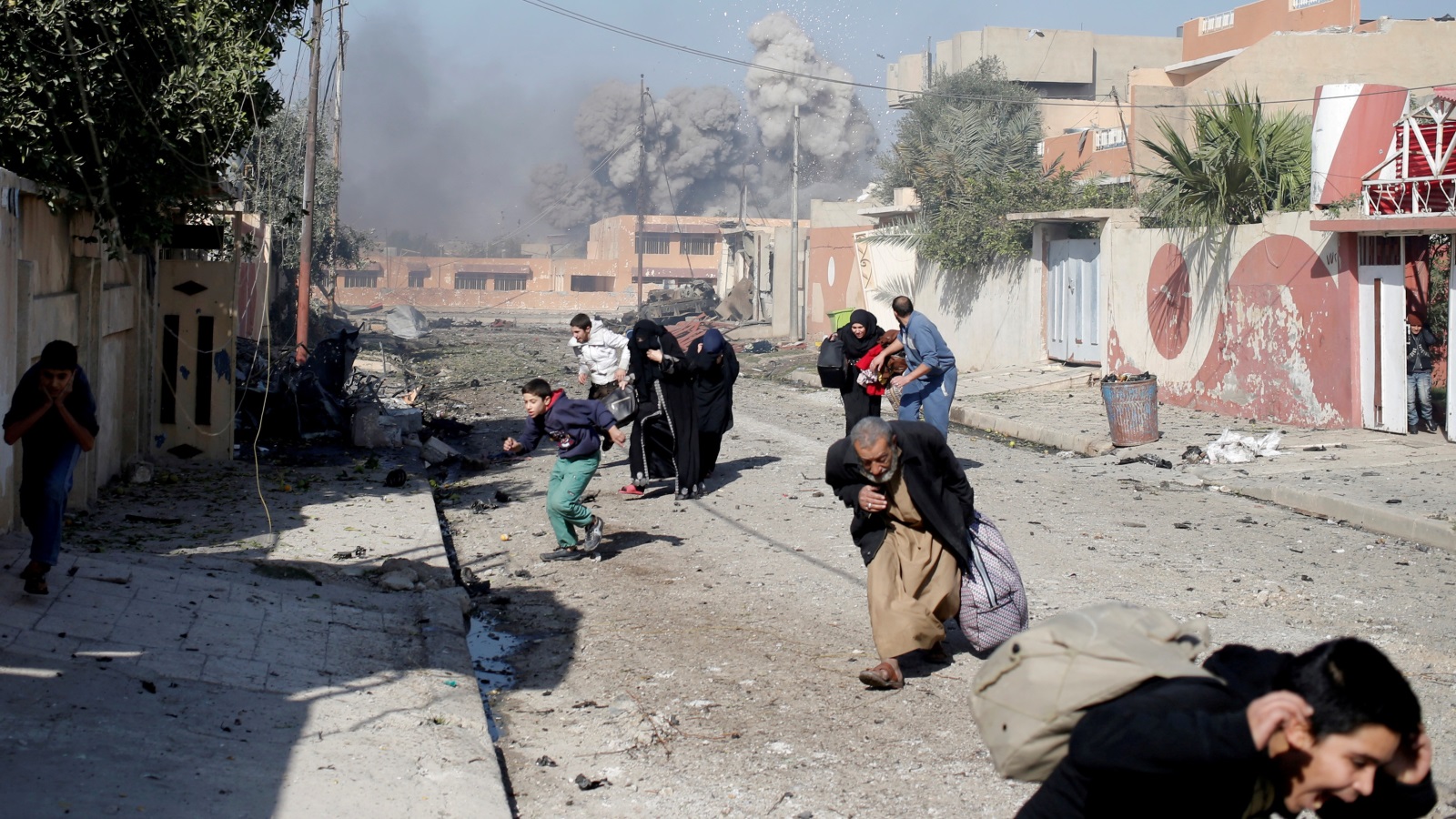 عراقيون أصيبوا بالهلع بعد قصف جوي للتحالف على مواقع لتنظيم الدولة في حي التحرير بالموصل أواخر 2016 (رويترز)