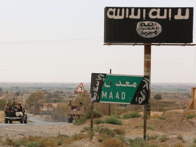 A vehicle drives past a billboard bearing the logo of the Islamic State (IS) group in Madan area, in the countryside of Deir Ezzor, on September 24, 2017, as Syrian government forces continue to press forward with Russian air cover in the offensive against the jihadists across the province. / AFP PHOTO / STRINGER (Photo credit should read STRINGER/AFP/Getty Images)